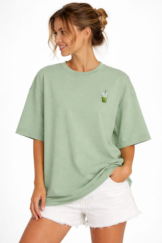 Woman wearing a green t-shirt with a small graphic on a white background